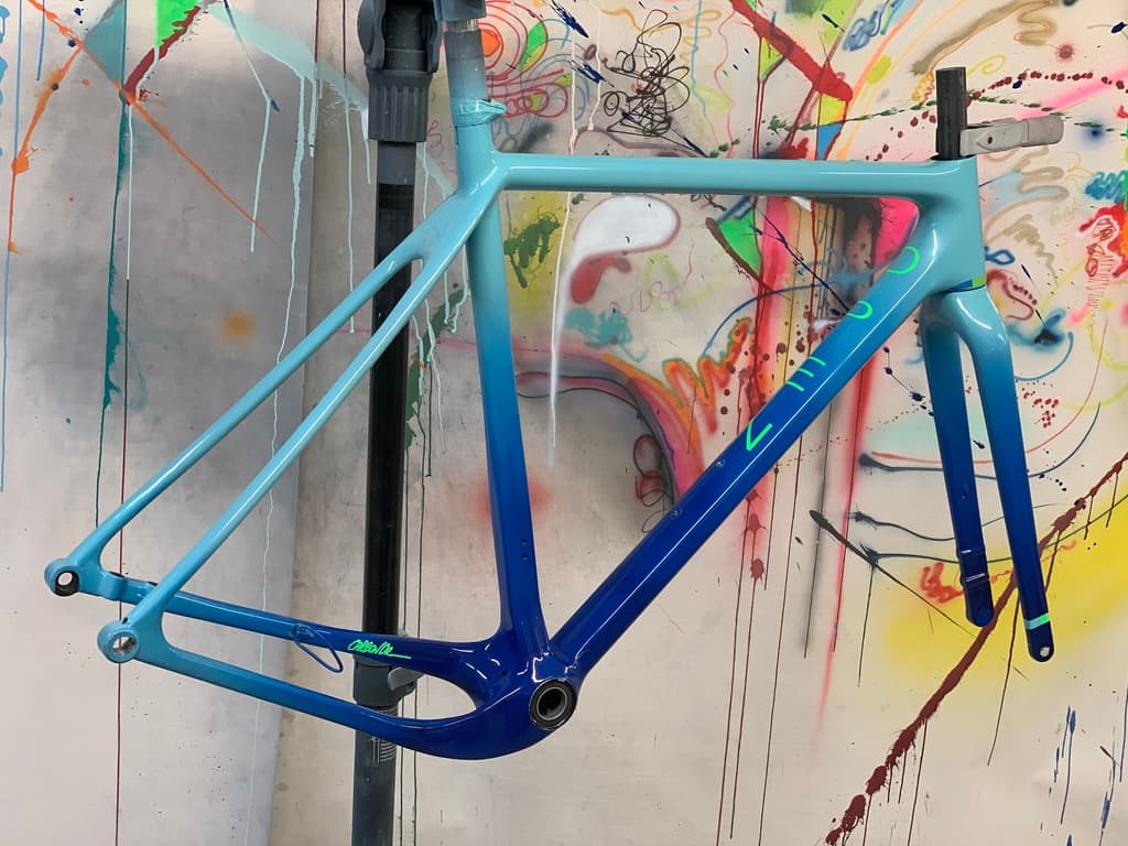 Aero road frame finished with a fade from teal to matte black, shown with a "CarbonDr" signature added near the seat tube.