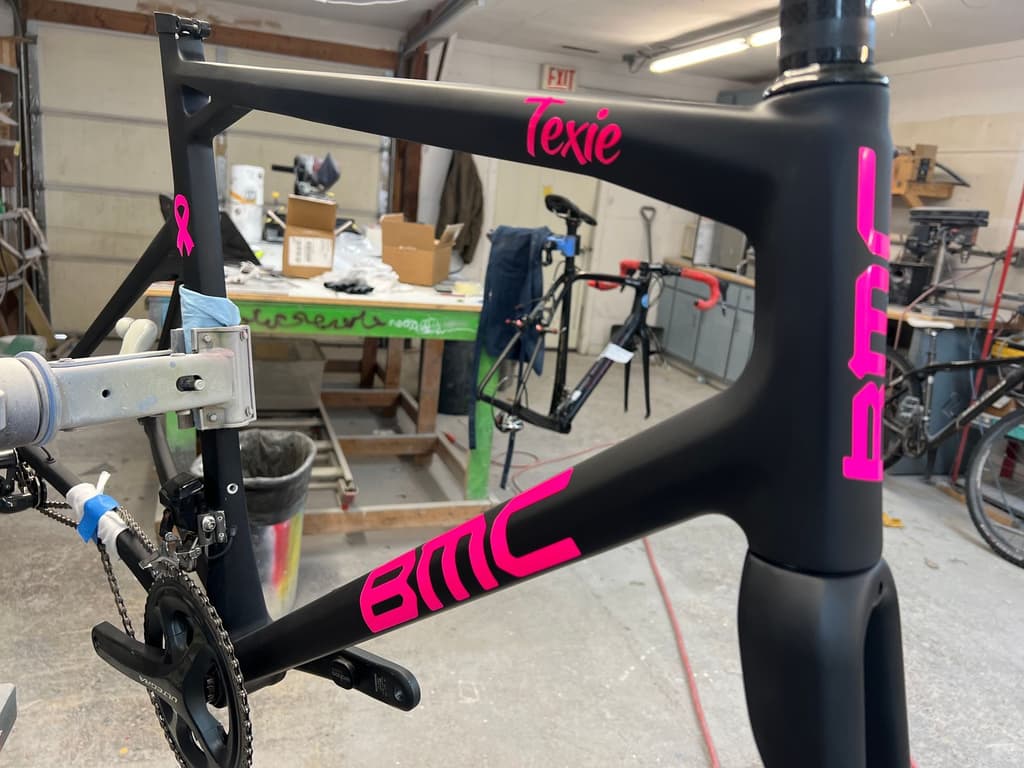 BMC road frame refinished in matte black with a pink ribbon graphic added to the top tube.