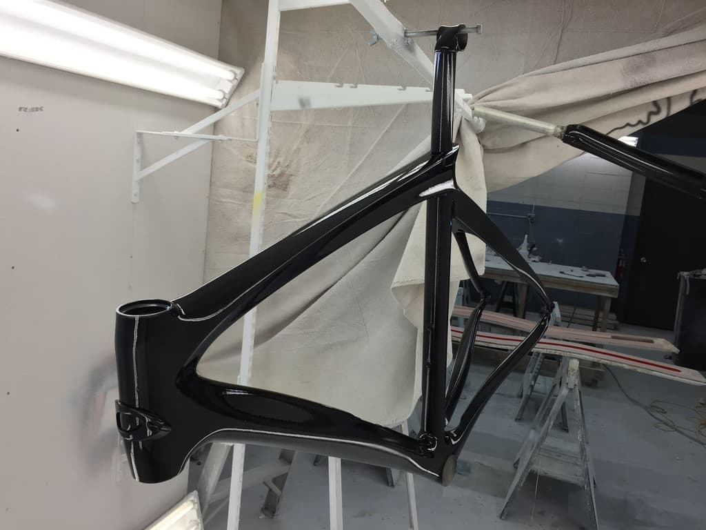 Aero road frame refinished in a deep gloss black, photographed in the shop.