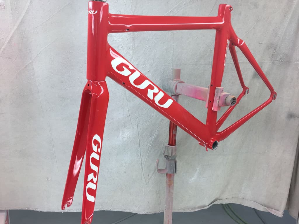 Guru road frame refinished in gloss red with white "Guru" lettering reproduced on the top tube, down tube, and fork.