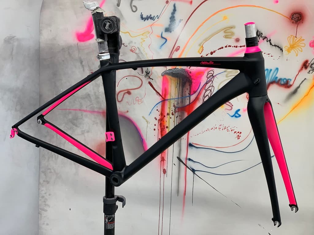 Frame refinished in matte black with hot pink accent panels on the fork legs and chain stay, with a "CarbonDr" signature added.