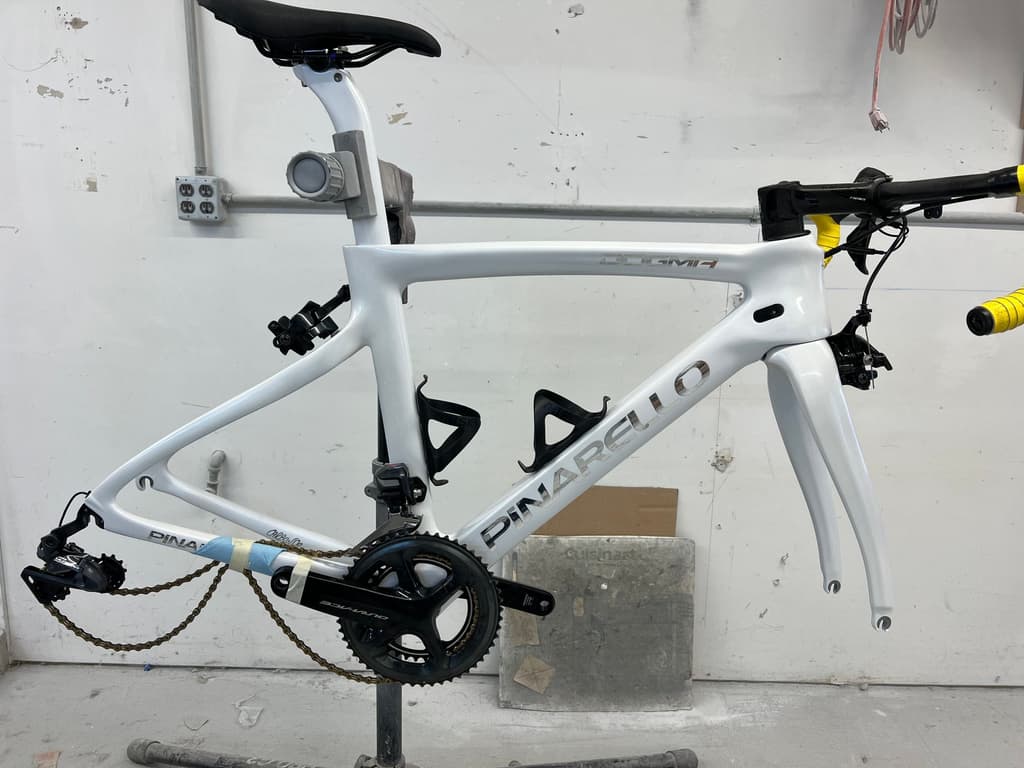 Fully built Pinarello Dogma road frame refinished in gloss white with a factory-style logo repaint, shown assembled with a Shimano Dura-Ace groupset.
