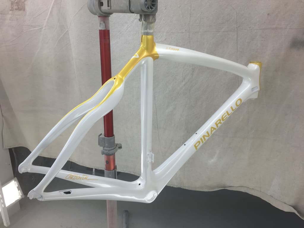 Pinarello road frame refinished in white with gold accent panels and reproduced logo lettering.