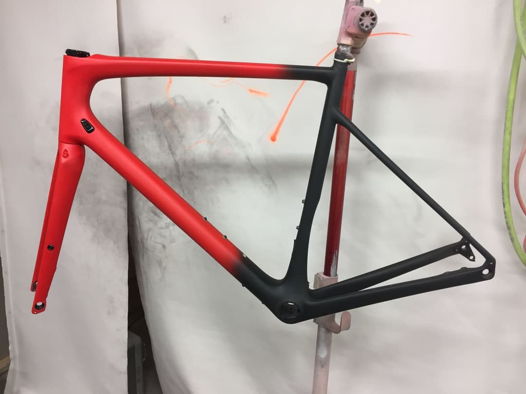 Frame finished with a matte fade from red at the head tube to black at the rear end.