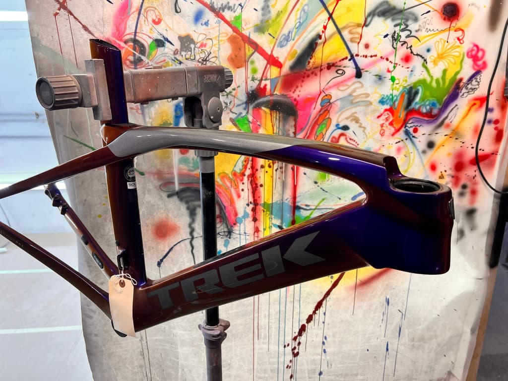 Trek Project One road frame finished with a custom fade from purple through grey, photographed in the spray booth.
