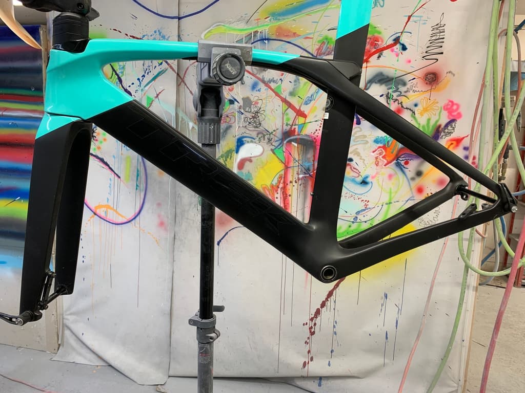 Trek road frame refinished with a gloss teal front triangle transitioning to matte black at the rear end and fork.